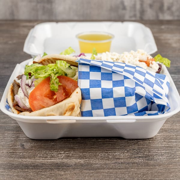 Tony's Gyros Greek Cuisine takeout container with two gyros, one wrapped in blue and white checkered paper.