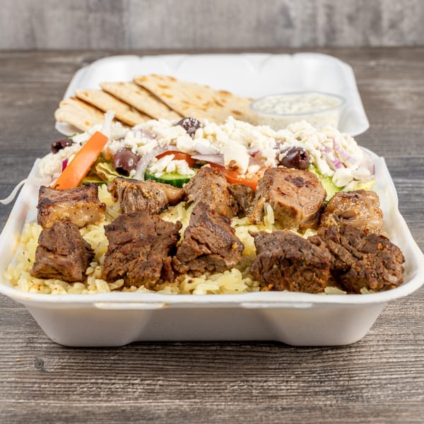 Tony's Gyros Greek Cuisine takeout container with rice, meat, Greek salad, pita, and tzatziki.