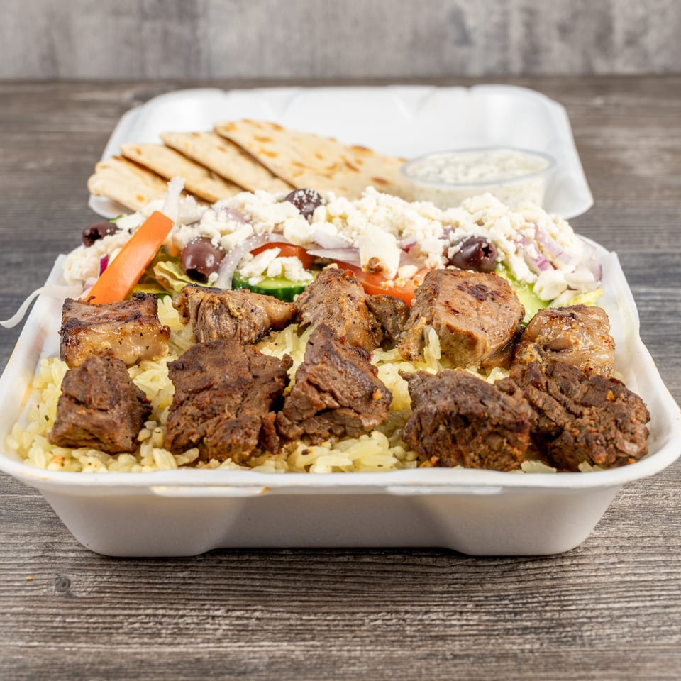 Tony's Gyros Greek Cuisine takeout container with rice, meat, Greek salad, pita, and tzatziki.